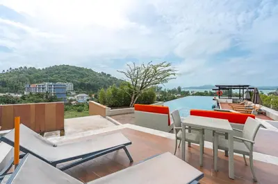 a balcony with a table and chairs and a boat at C207 Rooftop Pool & King Bed, Walk to Surin Beach in Surin Beach