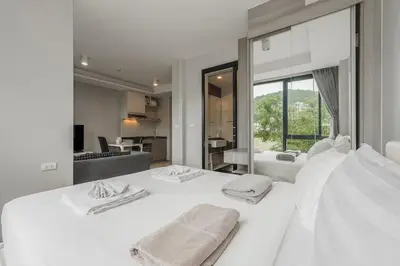 a bedroom with two white beds with towels on them at C207 Rooftop Pool & King Bed, Walk to Surin Beach in Surin Beach