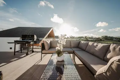 a living room with a couch and a piano on a roof at The Ozone Residences Bangtao in Phuket