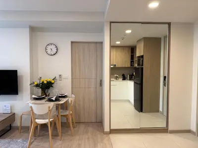 a dining room and kitchen with a table and a clock at 2BR Rooftop Pool & Gym Laguna Skypark in Laguna Phuket