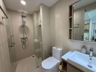a bathroom with a shower and a toilet and a sink at 2BR Rooftop Pool & Gym Laguna Skypark in Laguna Phuket