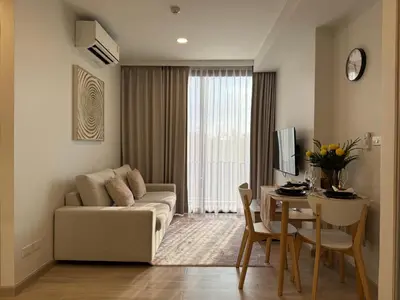 a living room with a couch and a table at 2BR Rooftop Pool & Gym Laguna Skypark in Laguna Phuket