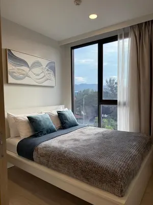 a bedroom with a bed with a large window at 2BR Rooftop Pool & Gym Laguna Skypark in Laguna Phuket