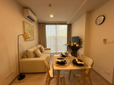a living room with a table and a couch at 2BR Rooftop Pool & Gym Laguna Skypark in Laguna Phuket