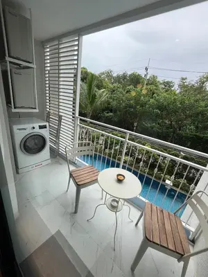 a balcony with a table and chairs and a pool at МЕ4 Halo NEW2 ВатСaп66935B2I976 in Nai Yang Beach