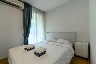 a bedroom with a white bed with two towels on it at Zcape 2 Phuket by RESAVA in Bang Tao Beach