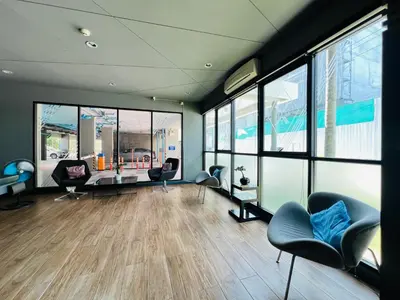 a waiting room with chairs and tables and windows at Zcape 2 Phuket by RESAVA in Bang Tao Beach