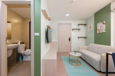 a living room with a couch and a bathroom at C210 Peaceful Retreat in Heart of Phuket in Kathu