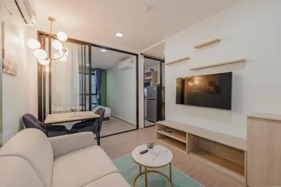 a living room with a couch and a tv on a wall at C210 Peaceful Retreat in Heart of Phuket in Kathu