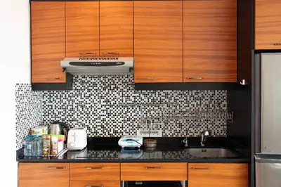a kitchen with wooden cabinets and a black counter top at Private 2 Bedroom Seaview at Patong Phuket in Patong Beach