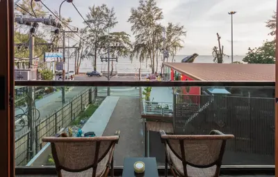 a balcony with two chairs and a view of a street at The Legacy V Beachfront Resort Ao Nang Krabi, Aspira Collection - Adults only in Ao Nang Beach