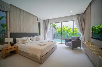 a bedroom with a bed and a chair and a television at 3BR Villa Z by NLA in Bang Tao Beach