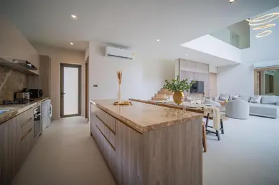 a kitchen and living room with a counter and a table at 3BR Villa Z by NLA in Bang Tao Beach