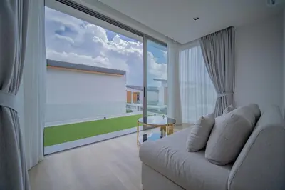 a living room with a white couch and a large window at 3BR Villa Z by NLA in Bang Tao Beach