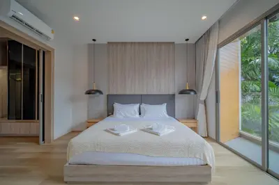 a bedroom with a large bed with two plates on it at 3BR Villa Z by NLA in Bang Tao Beach