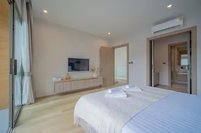 a bedroom with a white bed and a television at 3BR Villa Z by NLA in Bang Tao Beach