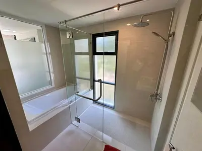a bathroom with a glass shower with a window at Apartment Title I, Rawai Phuket in Rawai Beach
