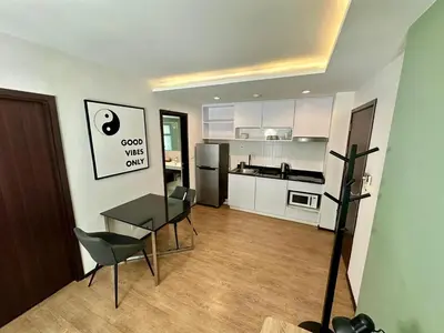 a living room with a table and chairs and a kitchen at Apartment Title I, Rawai Phuket in Rawai Beach