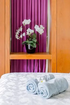 a bed with towels on it with a purple curtain at Serene Contemporary Villa with a Swimming Pool in Ban Saiyuan (1)
