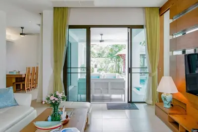a living room with a couch and a table at Serene Contemporary Villa with a Swimming Pool in Ban Saiyuan (1)