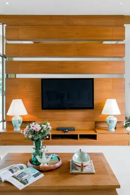 a living room with a tv and a wooden wall at Serene Contemporary Villa with a Swimming Pool in Ban Saiyuan (1)