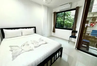a bedroom with a white bed with flowers on it at Patong Easy Life 3 in Patong Beach
