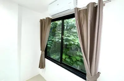 a window with brown curtains in a room at Patong Easy Life 3 in Patong Beach
