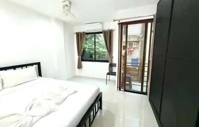 a white bedroom with a bed and a window at Patong Easy Life 3 in Patong Beach