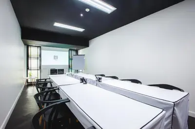 a conference room with a row of tables and chairs at Blu Monkey Hub and Hotel Phuket Town- Free All Day Coworking space in Phuket Town