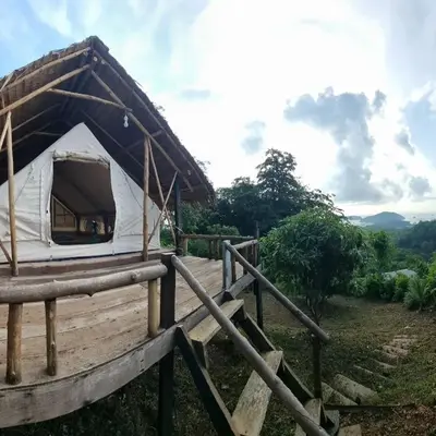 a tent with a thatched roof in a field at Sea True Valley Phuket ซี ทรู วัลเลย์ ภูเก็ต in Ban Ao Makham