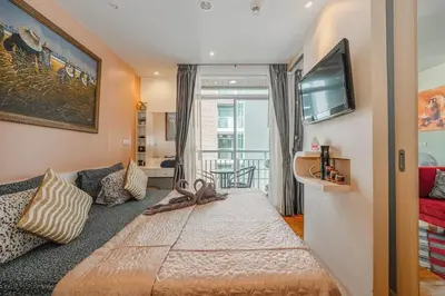 a bedroom with a large bed and a tv at C211 Motorbike Friendly 950m to Patong Beach Pool&Gym in Patong Beach
