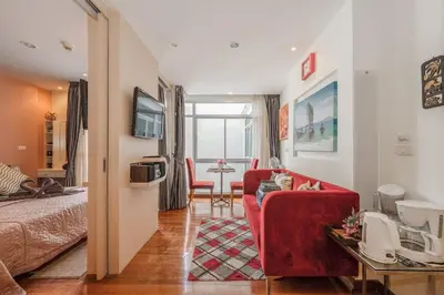 a living room with a red couch and a table at C211 Motorbike Friendly 950m to Patong Beach Pool&Gym in Patong Beach
