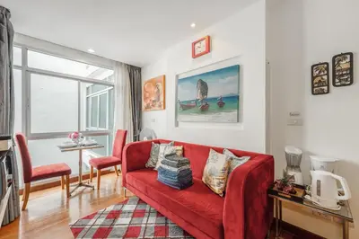 a living room with a red couch and a table at C211 Motorbike Friendly 950m to Patong Beach Pool&Gym in Patong Beach