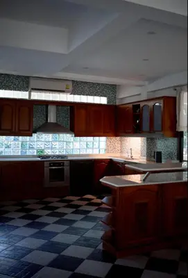 a kitchen with wooden cabinets and a checkered floor at Вилла с 6 спальнями в районе Раваи in Ban Suan