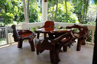 a wooden table and chairs on a porch at Вилла с 6 спальнями в районе Раваи in Ban Suan