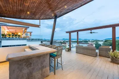 an outdoor kitchen with a bar on a roof at V210 Retreat 3BR Top of the Range, Sea View,Lift in Rawai Beach