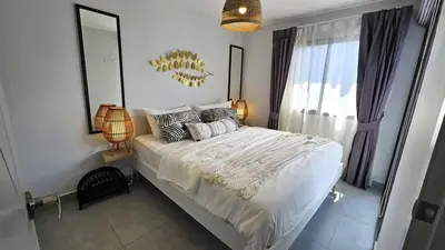 a bedroom with a large bed and a mirror at C212 Relaxing Condo Rooftop Pool & Ocean Views in Chalong