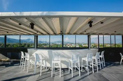 a group of white chairs and a table on a roof at C212 Relaxing Condo Rooftop Pool & Ocean Views in Chalong