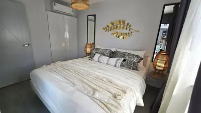 a bedroom with a large white bed with pillows at C212 Relaxing Condo Rooftop Pool & Ocean Views in Chalong