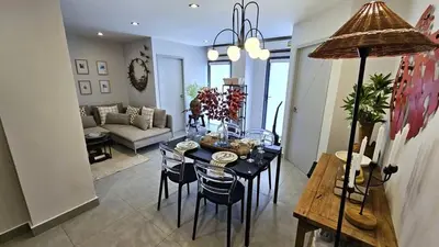 a living room with a table with chairs and a couch at C212 Relaxing Condo Rooftop Pool & Ocean Views in Chalong