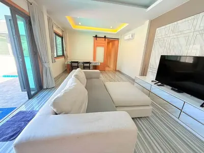 a living room with a couch and a flat screen tv at Quiet Harbor in Ban Saiyuan (1)