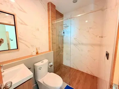 a bathroom with a toilet and a glass shower at Quiet Harbor in Ban Saiyuan (1)