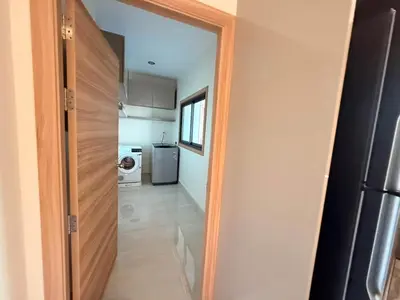 a door leading into a kitchen with a refrigerator at Quiet Harbor in Ban Saiyuan (1)