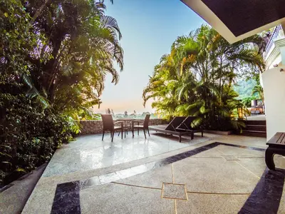 a patio with a table and chairs overlooking the ocean at Luxury 8 - 9 Bedroom Villa With 2 Pools in Kamala Beach