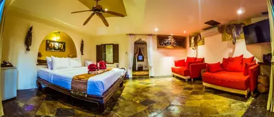 a bedroom with a bed and a couch and a fan at Luxury 8 - 9 Bedroom Villa With 2 Pools in Kamala Beach