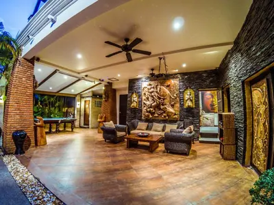 a living room with a ceiling fan and a brick wall at Luxury 8 - 9 Bedroom Villa With 2 Pools in Kamala Beach