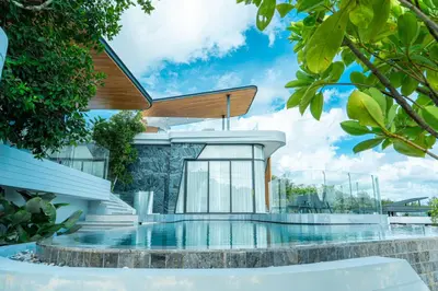 a house with a swimming pool in front of it at Zavaya Luxury Private Pool Villa Phuket in Layan Beach