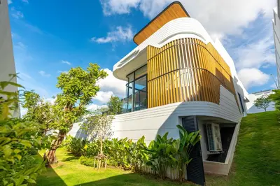 a house with a yellow and white facade at Zavaya Luxury Private Pool Villa Phuket in Layan Beach