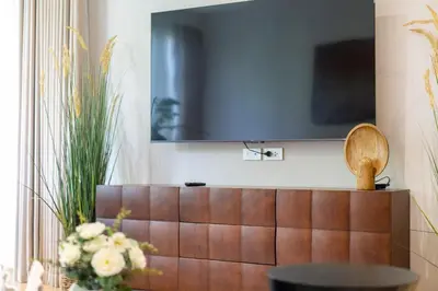 a living room with a television on a wall at Laguna Beachside Apartment 300 meters to the Bangtao Beach in Bang Tao Beach