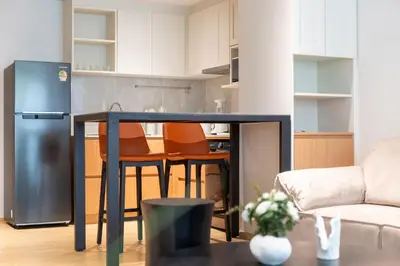 a kitchen with a table and a refrigerator in a room at Laguna Beachside Apartment 300 meters to the Bangtao Beach in Bang Tao Beach